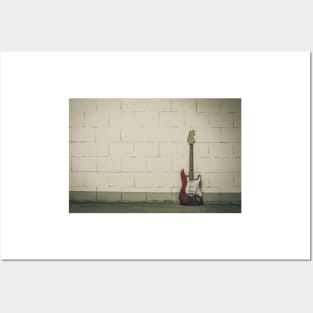 Red electric guitar against white brick wall Posters and Art